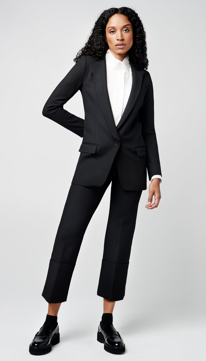 A woman in a solid black blazer and cuffed pant.