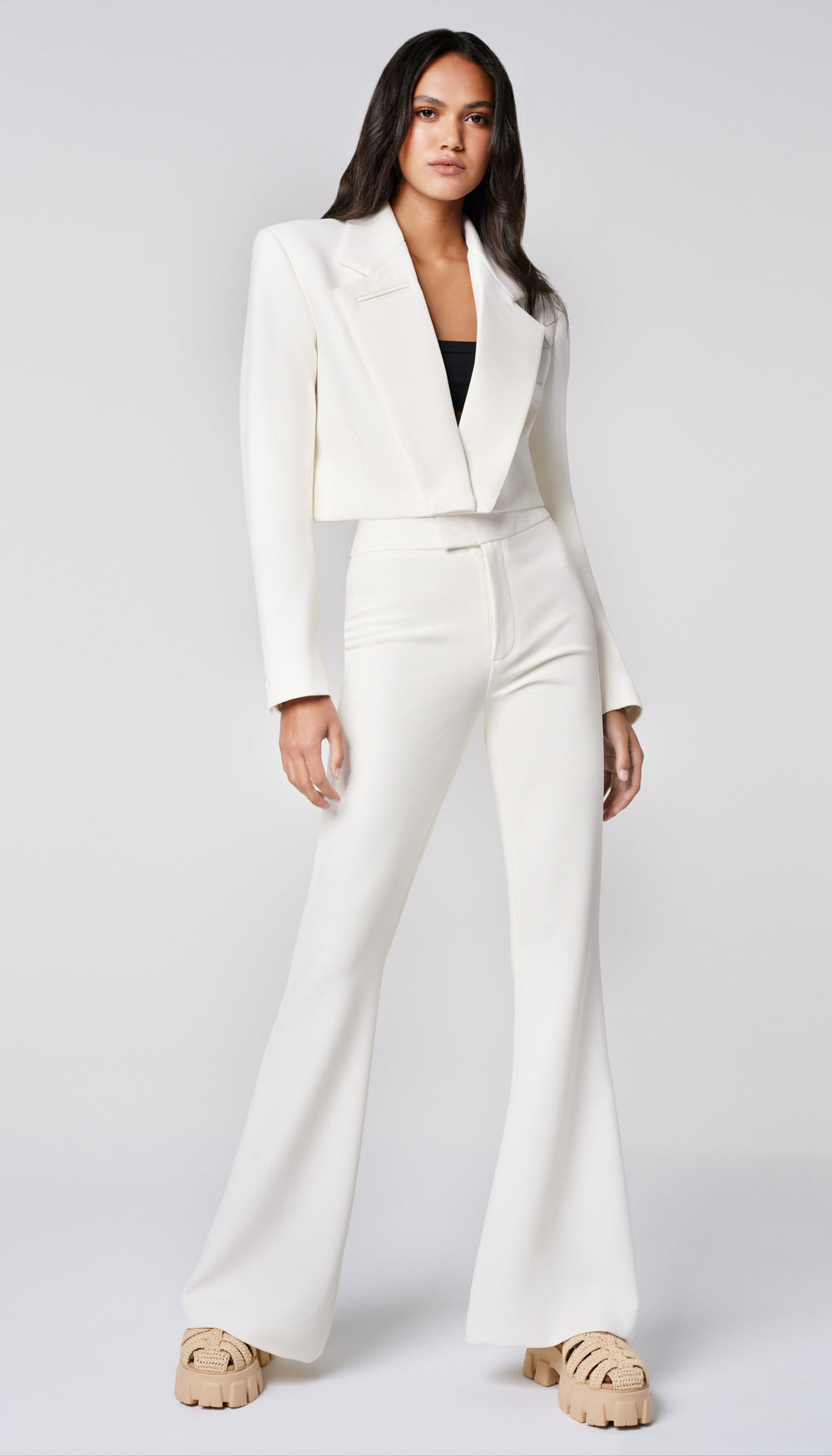 A woman in a white blazer and pant.