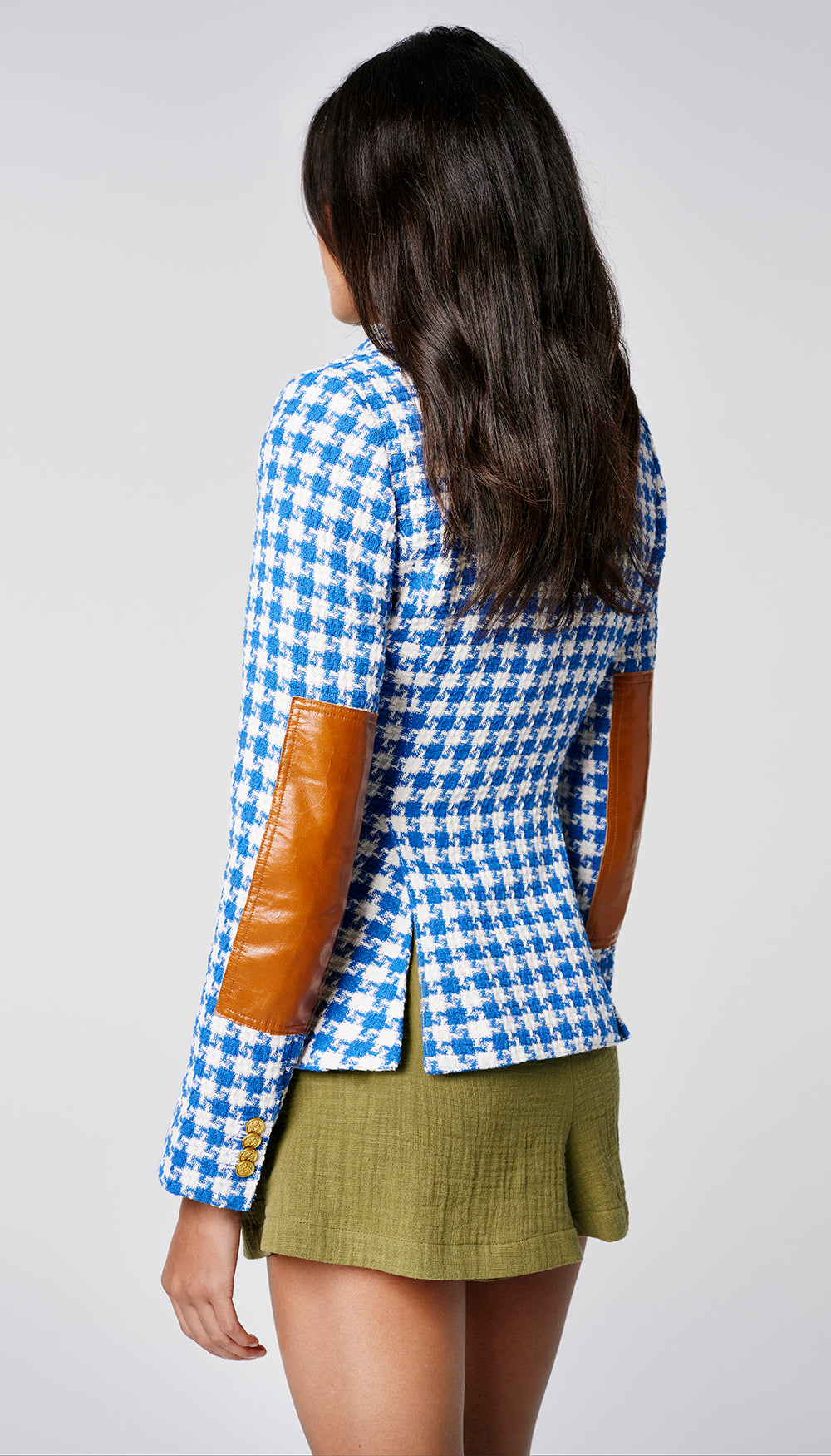 The back of a woman in a blue and white houndstooth blazer.