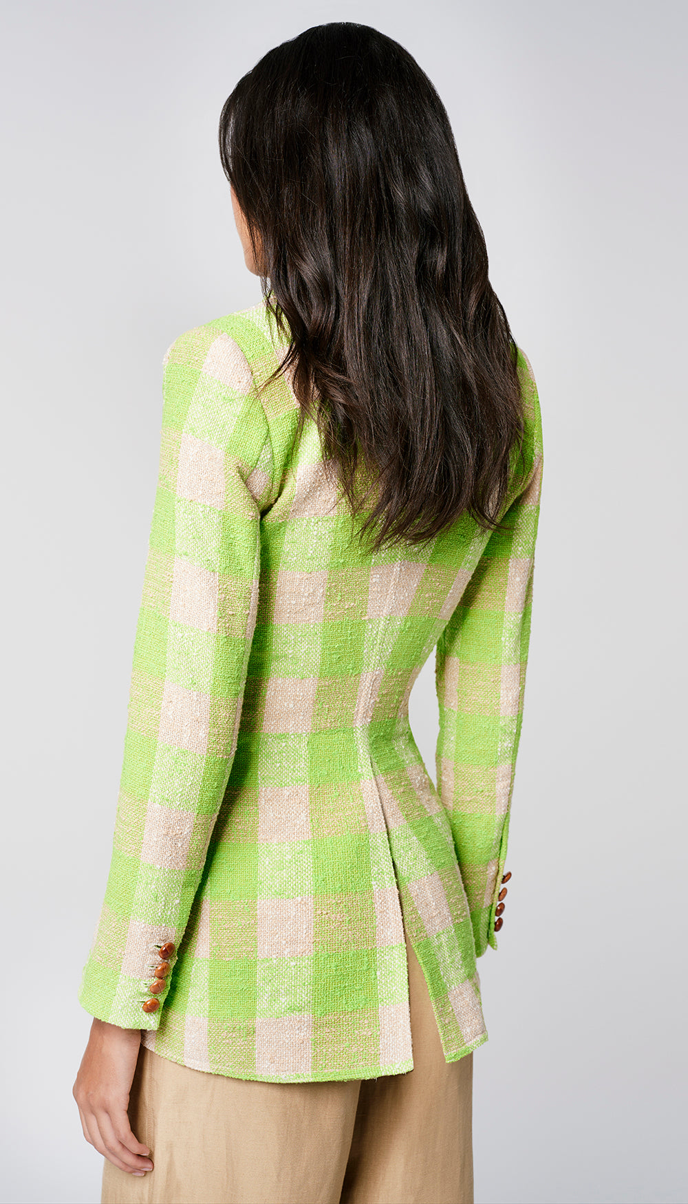 The back of a woman in a green check blazer.