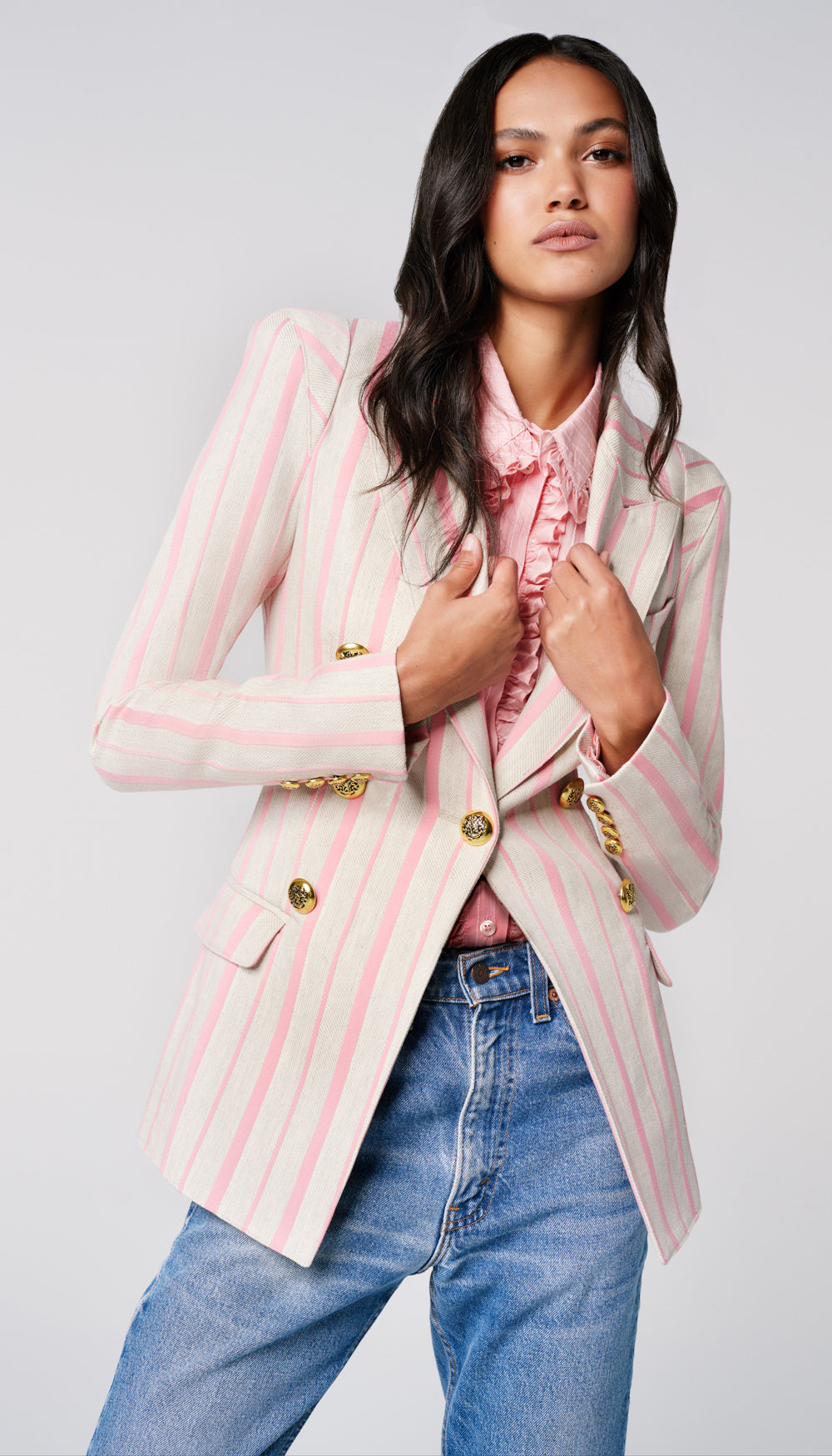 A woman in a stone and rose stripe blazer.