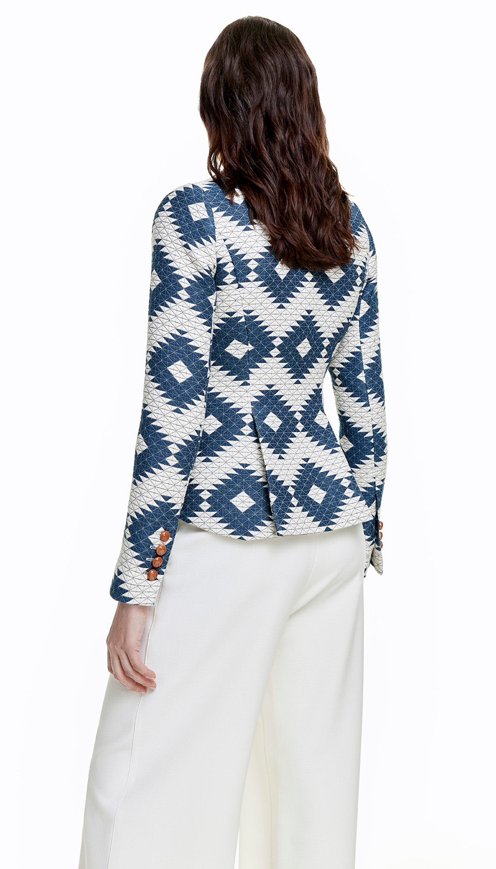 The back of a woman in a blue and white quilted blazer.