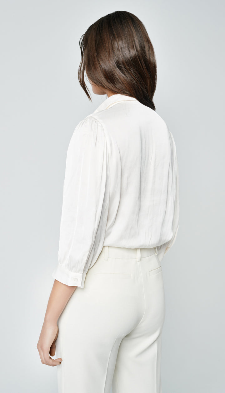 The back of a woman in a white blouse.